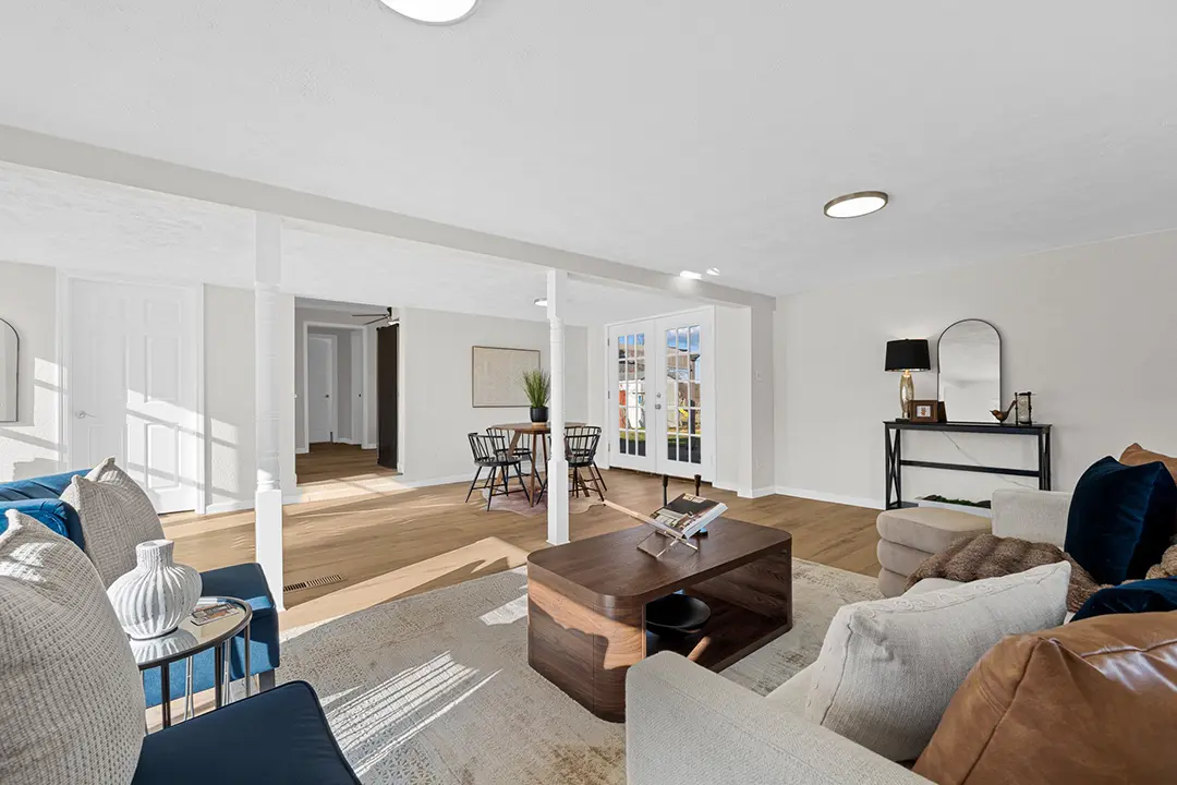 Open living and dining room with hardwood floors, white walls, and natural light